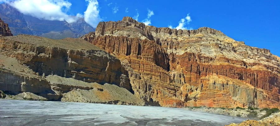 Layered red and grey eroded cliffs in the high desert of Upper Mustang